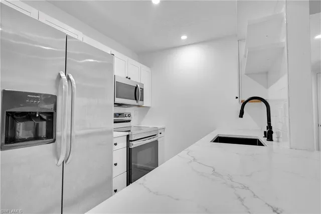 a kitchen with a sink stainless steel appliances and cabinets