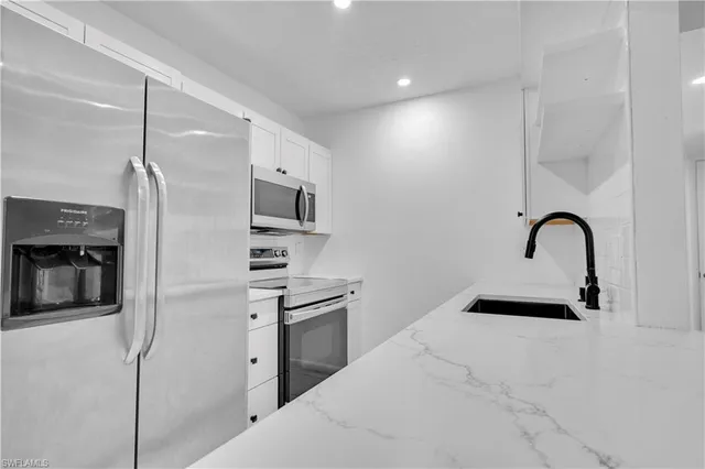 a kitchen with a sink stainless steel appliances and cabinets