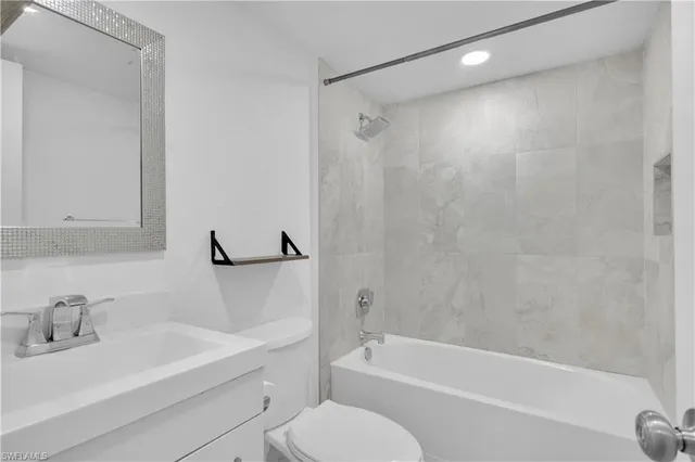 a bathroom with a bathtub shower sink vanity and toilet
