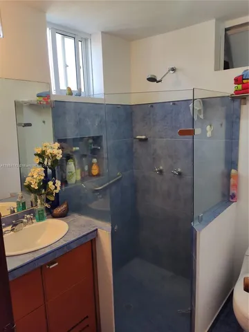 a bathroom with a sink a mirror and shower