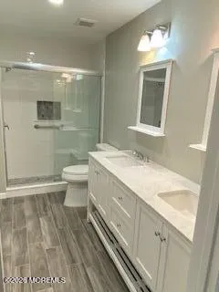 a bathroom with a granite countertop sink a toilet and a mirror