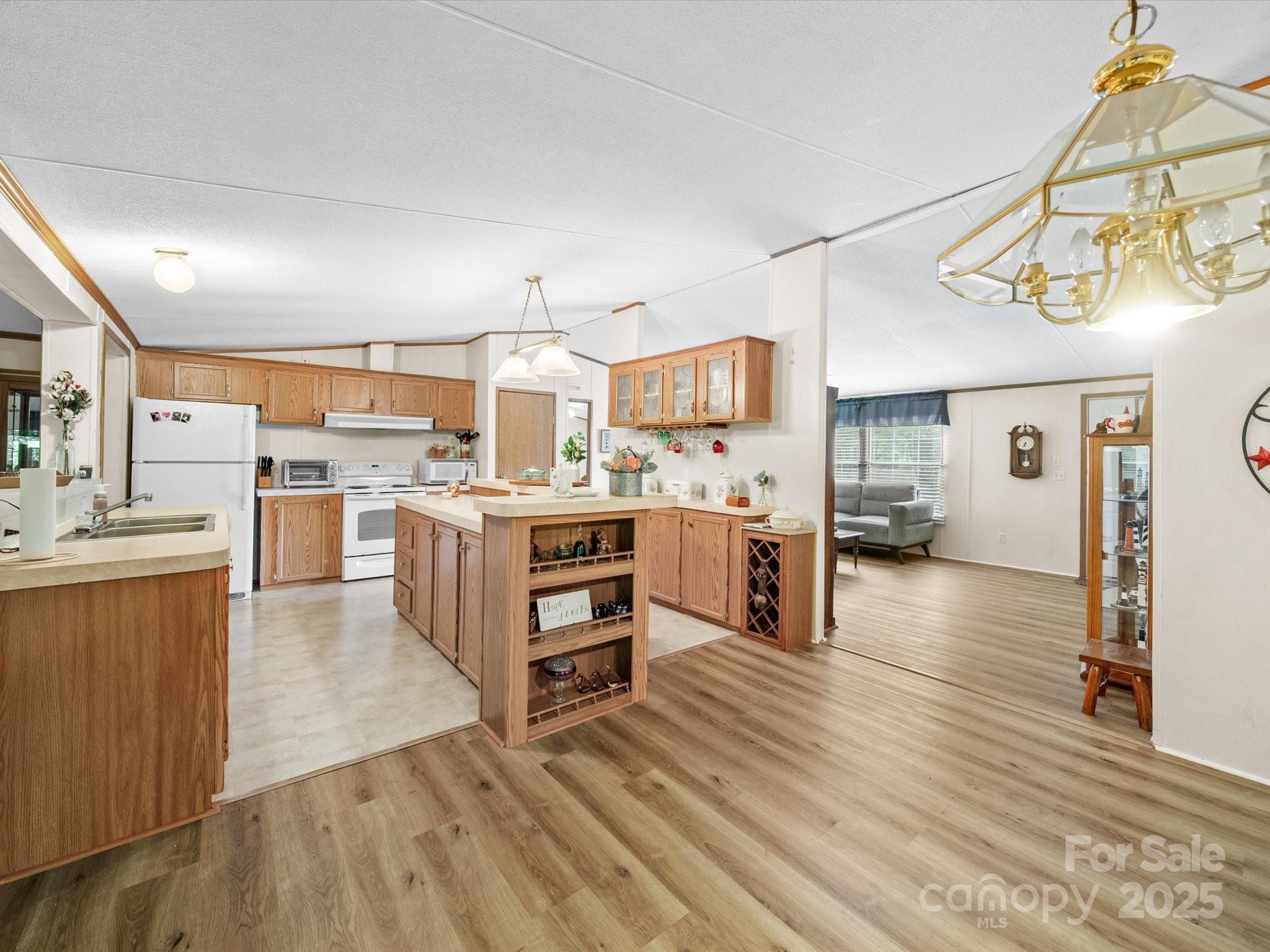 3911 Doster Road Monroe, NC 28112 - Photo 19 of 34 a kitchen with stainless steel appliances kitchen island granite countertop a sink cabinets and wooden floor