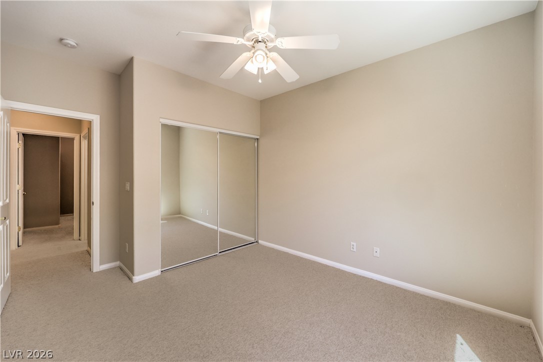 3713 Spring Shadow Road Las Vegas, NV 89129 - Photo 27 of 37 This ample bedroom includes soft carpeting and a mirrored closet, ensuring comfortable living.