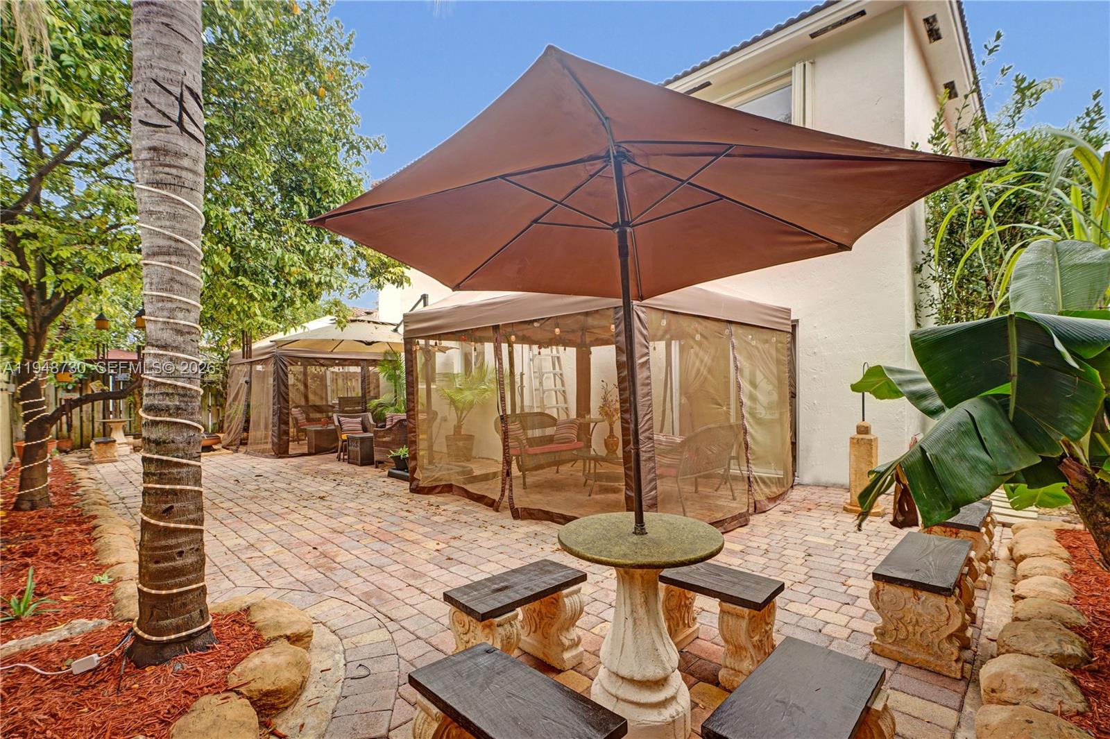 5502 Southwest 162nd Place Miami, FL 33185 - Photo 17 of 72 a view of a patio with table and chairs under an umbrella
