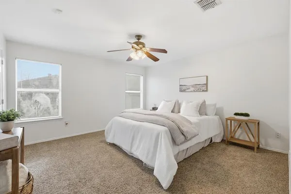 a spacious bedroom with a bed and a chandelier