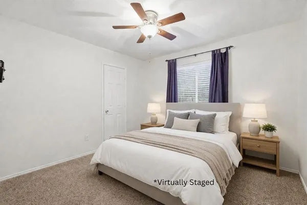 a bedroom with a large bed and a ceiling fan