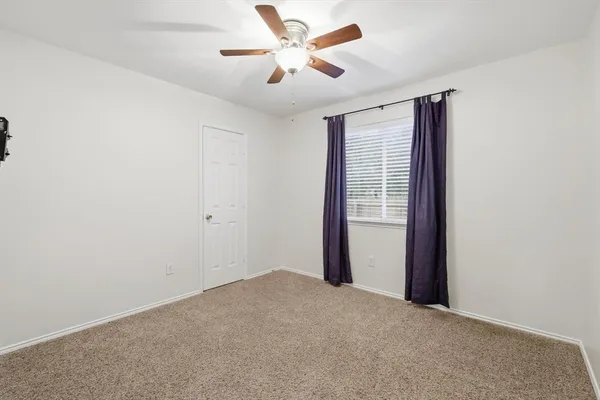 a view of a livingroom with a ceiling fan and window