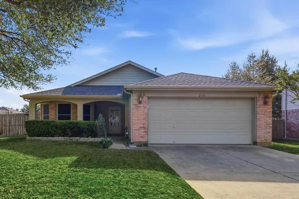 a front view of a house with a garden and yard