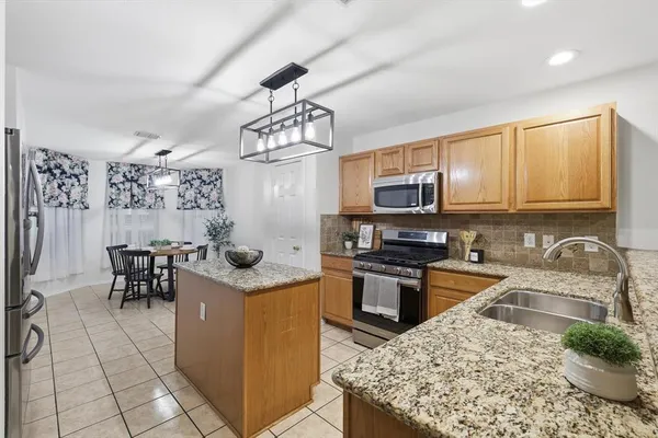 a kitchen with stainless steel appliances granite countertop a sink stove and microwave