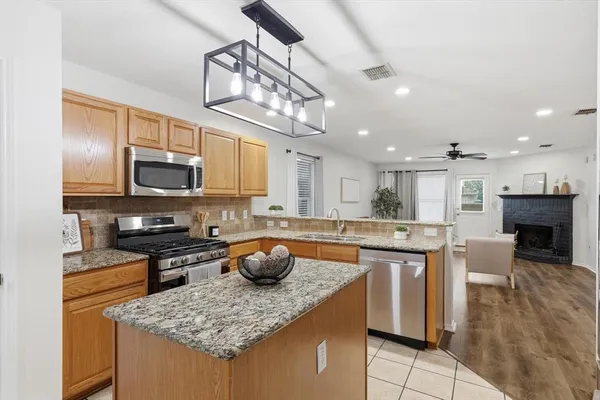 a kitchen with stainless steel appliances granite countertop a sink a stove top oven a counter space and cabinets