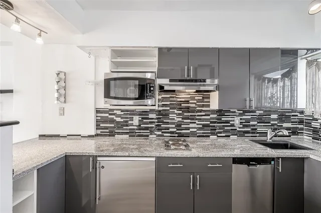 a kitchen with stainless steel appliances granite countertop a sink stove and microwave