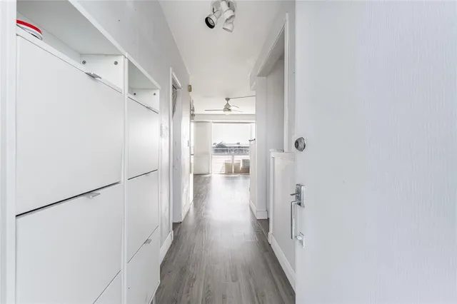 a view of a hallway with wooden floor and staircase