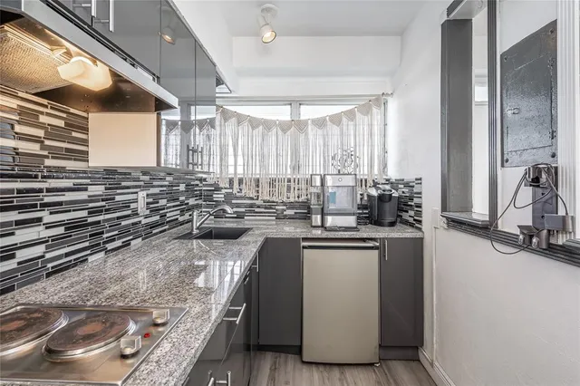 a kitchen with sink a window and chairs
