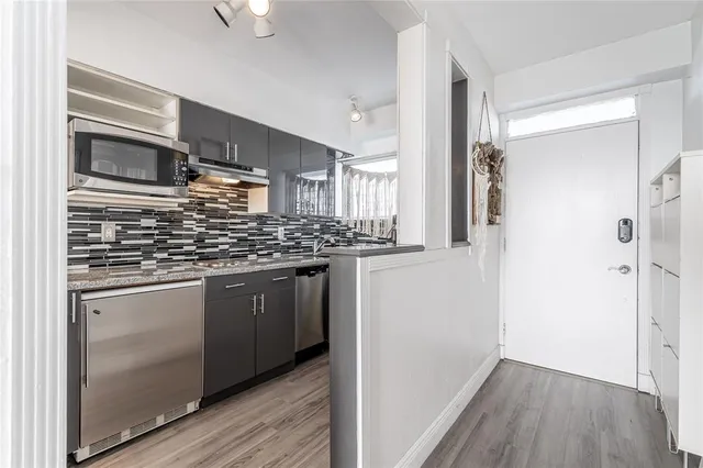 a kitchen with stainless steel appliances granite countertop a refrigerator and a sink
