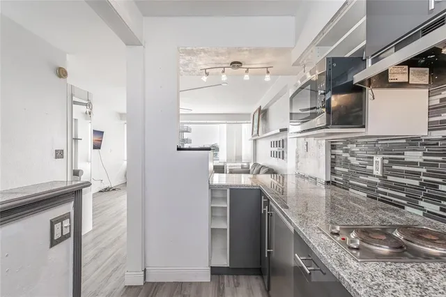 a kitchen with stainless steel appliances granite countertop a refrigerator and a stove