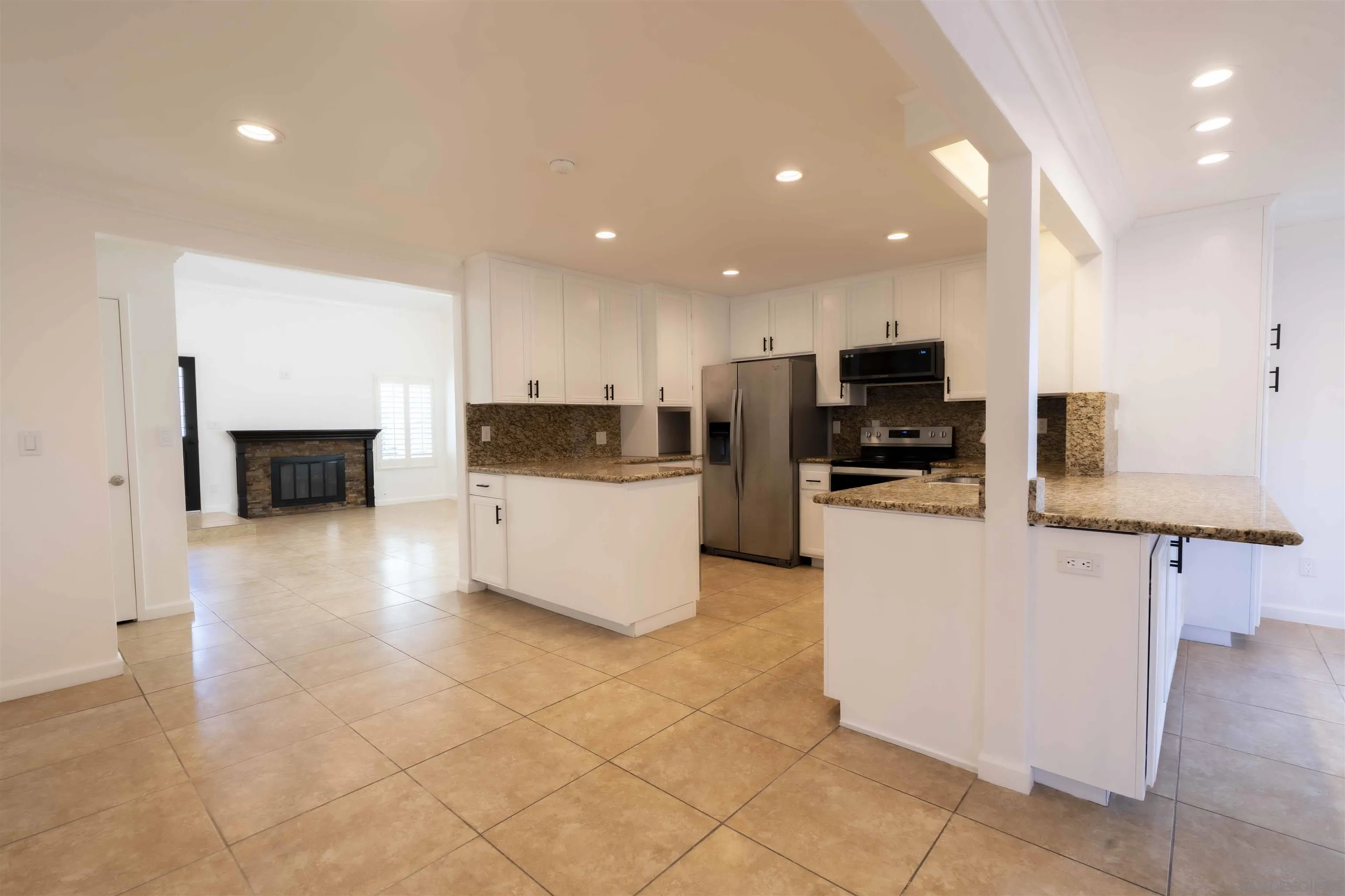 10858 Buggywhip Drive Spring Valley, CA 91978 - Photo 12 of 51 a kitchen with stainless steel appliances a stove top oven a sink a refrigerator and a center island