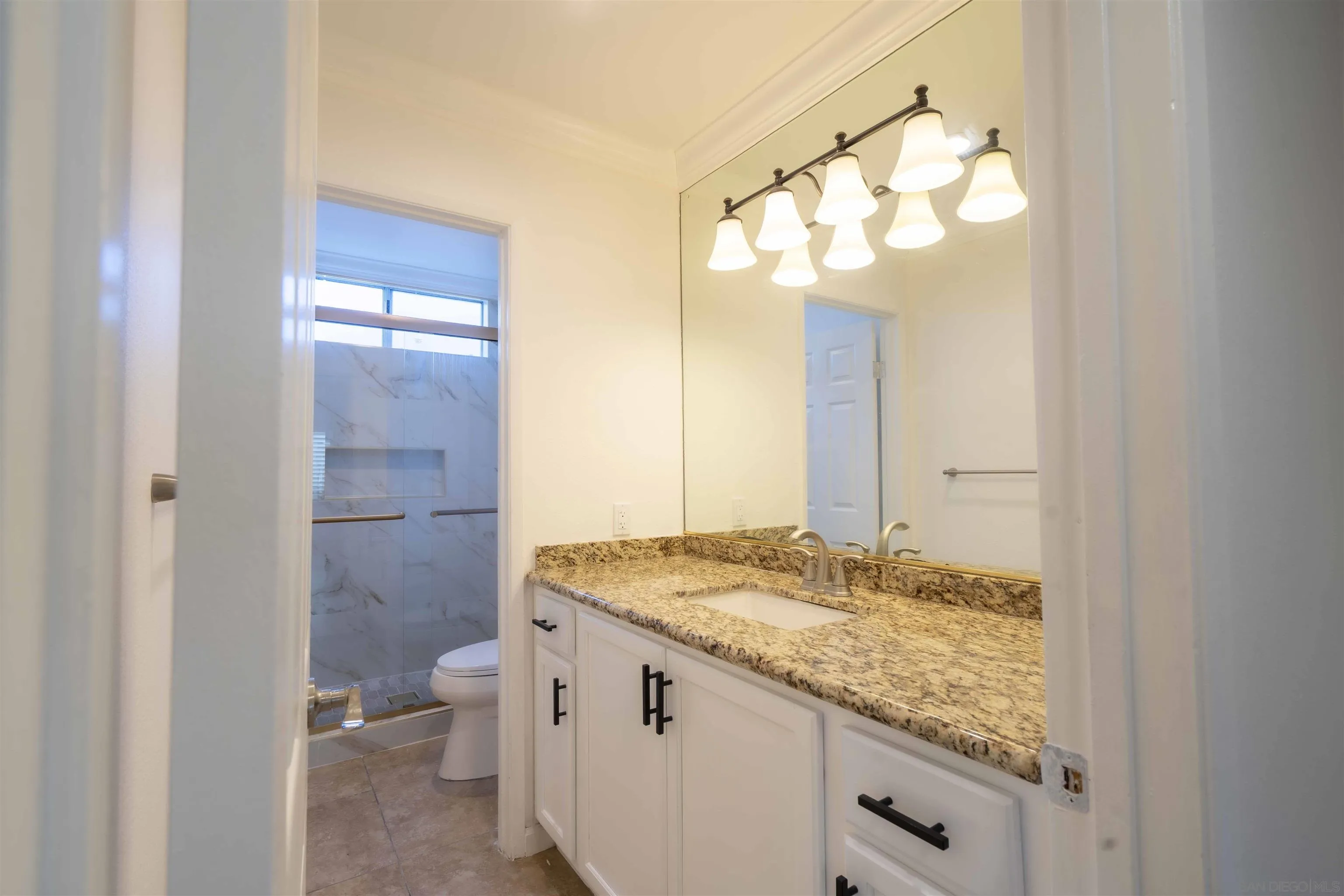 10858 Buggywhip Drive Spring Valley, CA 91978 - Photo 22 of 51 a bathroom with a granite countertop sink and a mirror