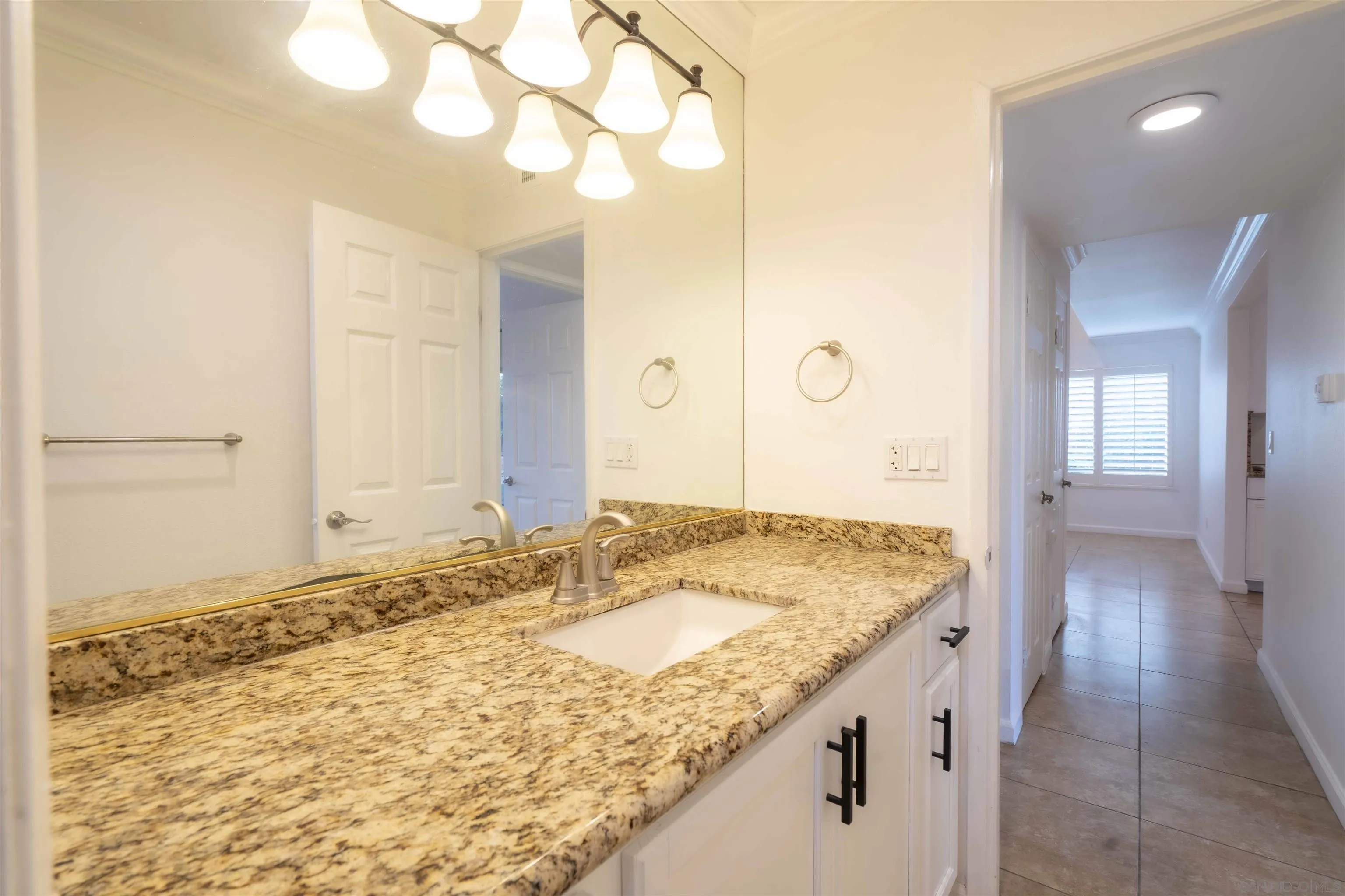 10858 Buggywhip Drive Spring Valley, CA 91978 - Photo 23 of 51 a bathroom with a granite countertop sink and a mirror