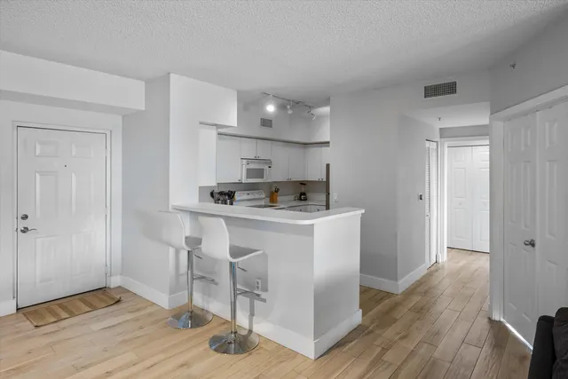 a kitchen with a refrigerator and white cabinets