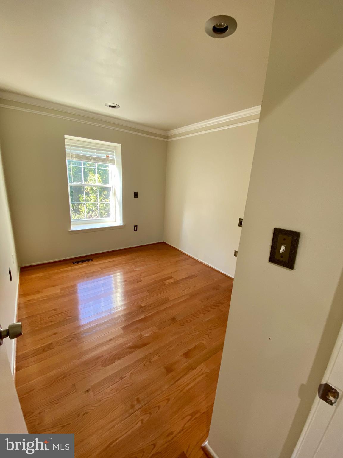 8852 Cork County Court Springfield, VA 22152 - Photo 18 of 31 a view of an empty room with a window and wooden floor