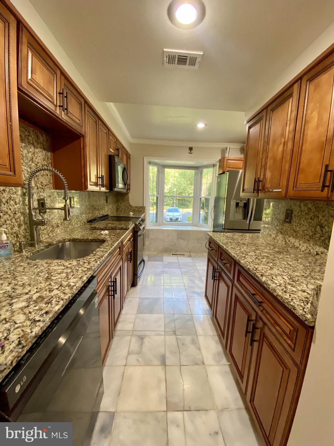 8852 Cork County Court Springfield, VA 22152 - Photo 4 of 31 a large kitchen with stainless steel appliances granite countertop a stove a sink and a microwave