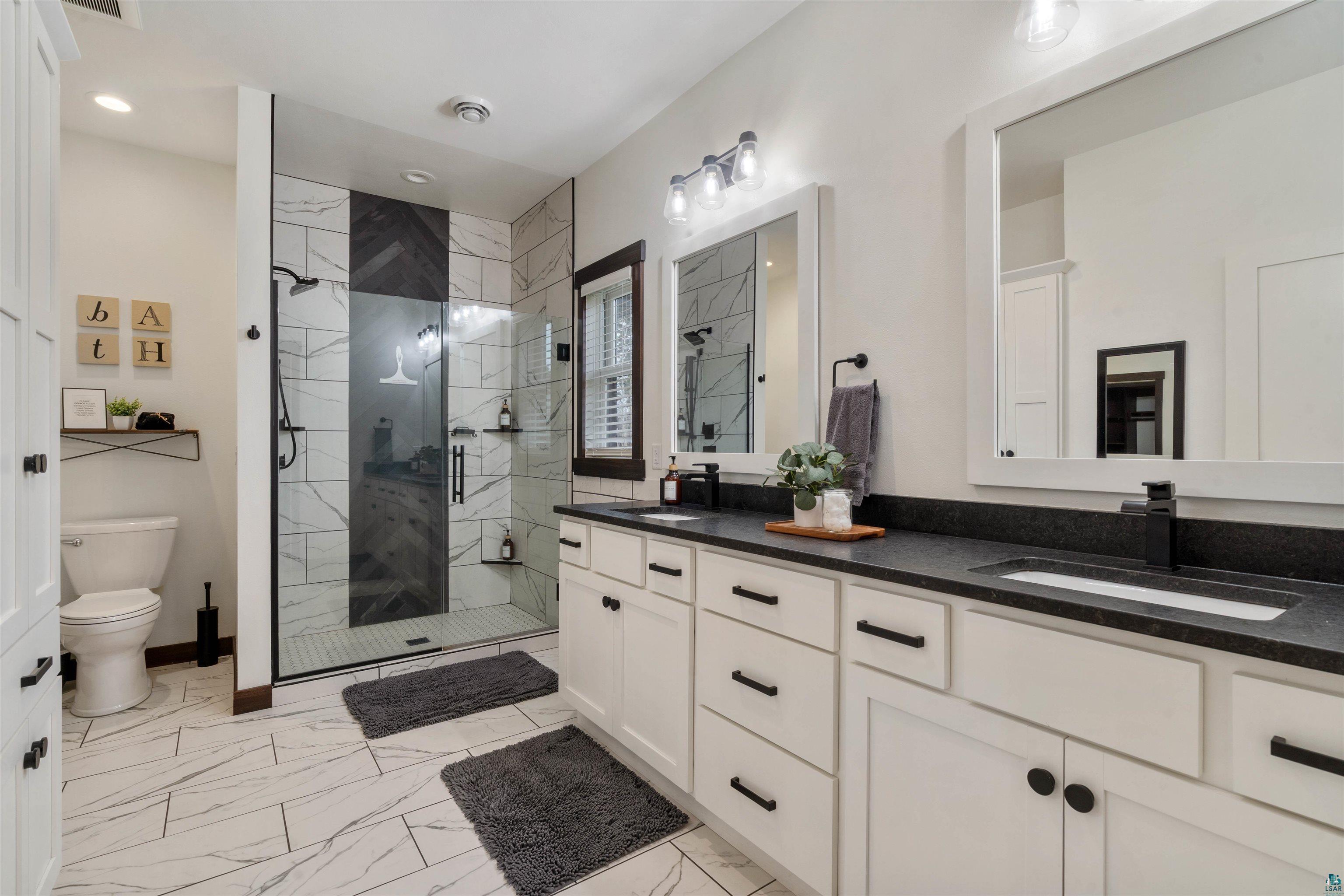 59 East Riverside Road Esko, MN 55733 - Photo 19 of 48 Full bathroom with double vanity, light marble finish flooring, and a marble finish shower