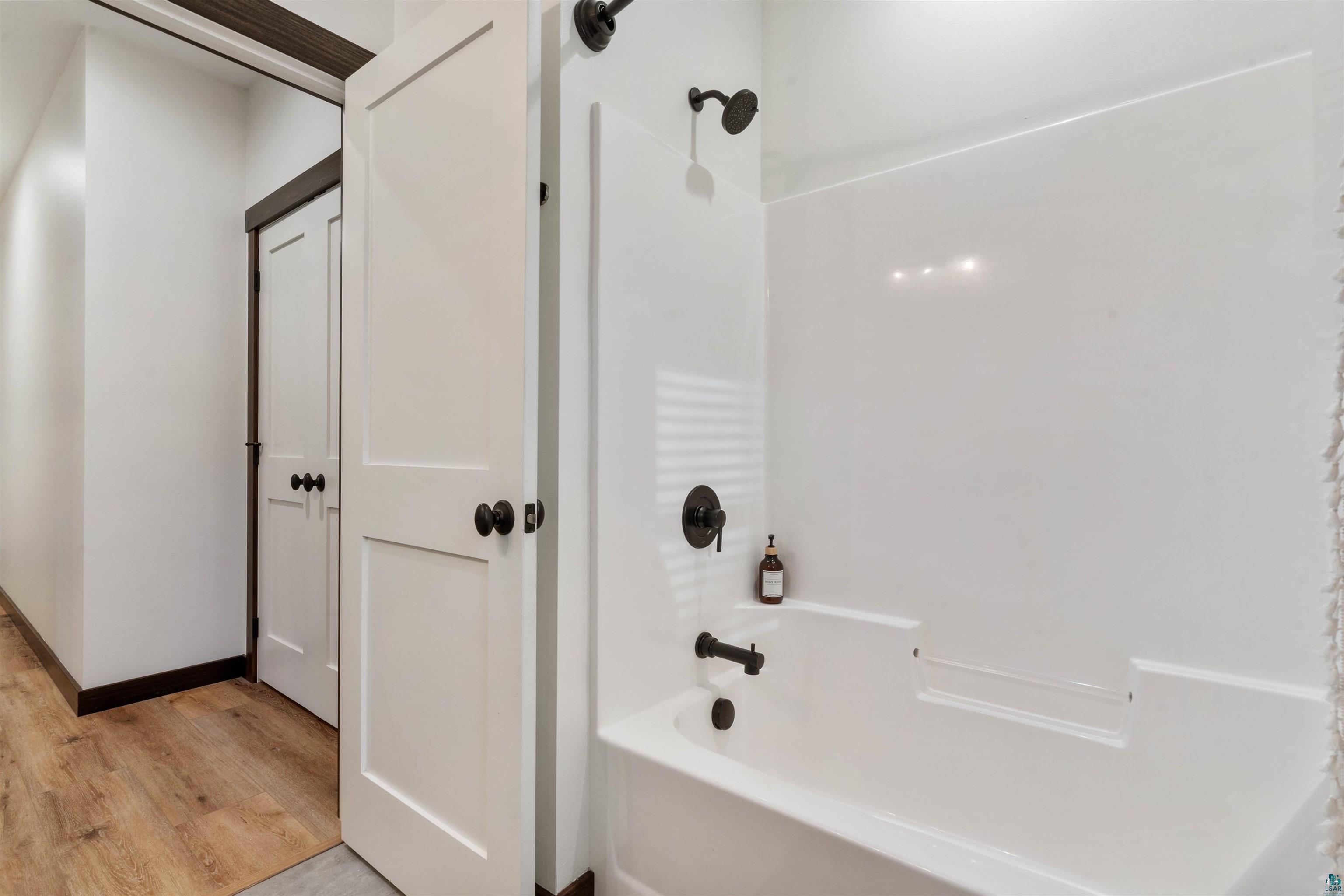 59 East Riverside Road Esko, MN 55733 - Photo 24 of 48 Bathroom with washtub / shower combination and light wood-style flooring