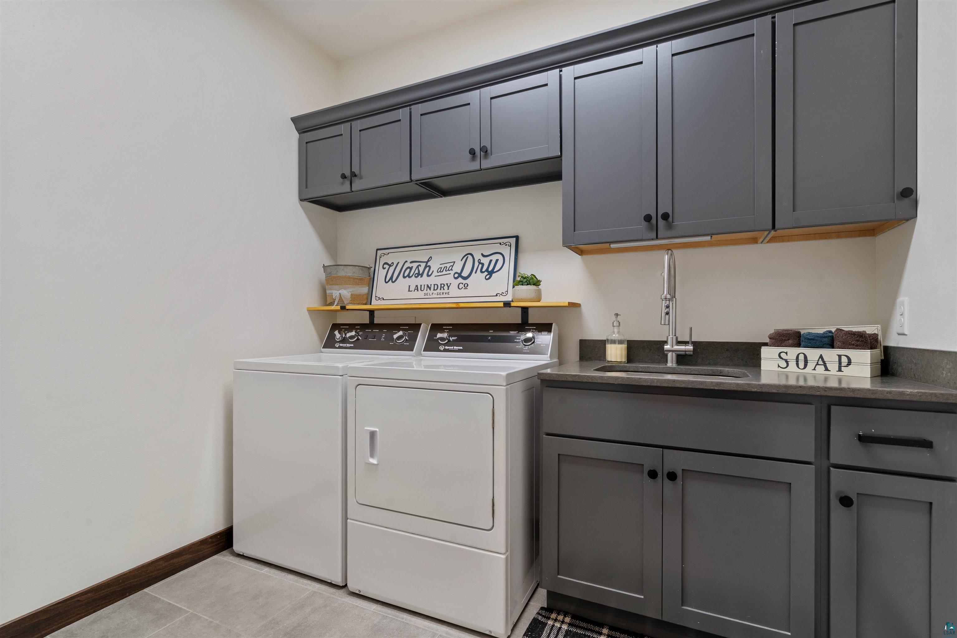 59 East Riverside Road Esko, MN 55733 - Photo 26 of 48 Laundry room featuring washer and dryer, cabinet space, and light tile patterned floors