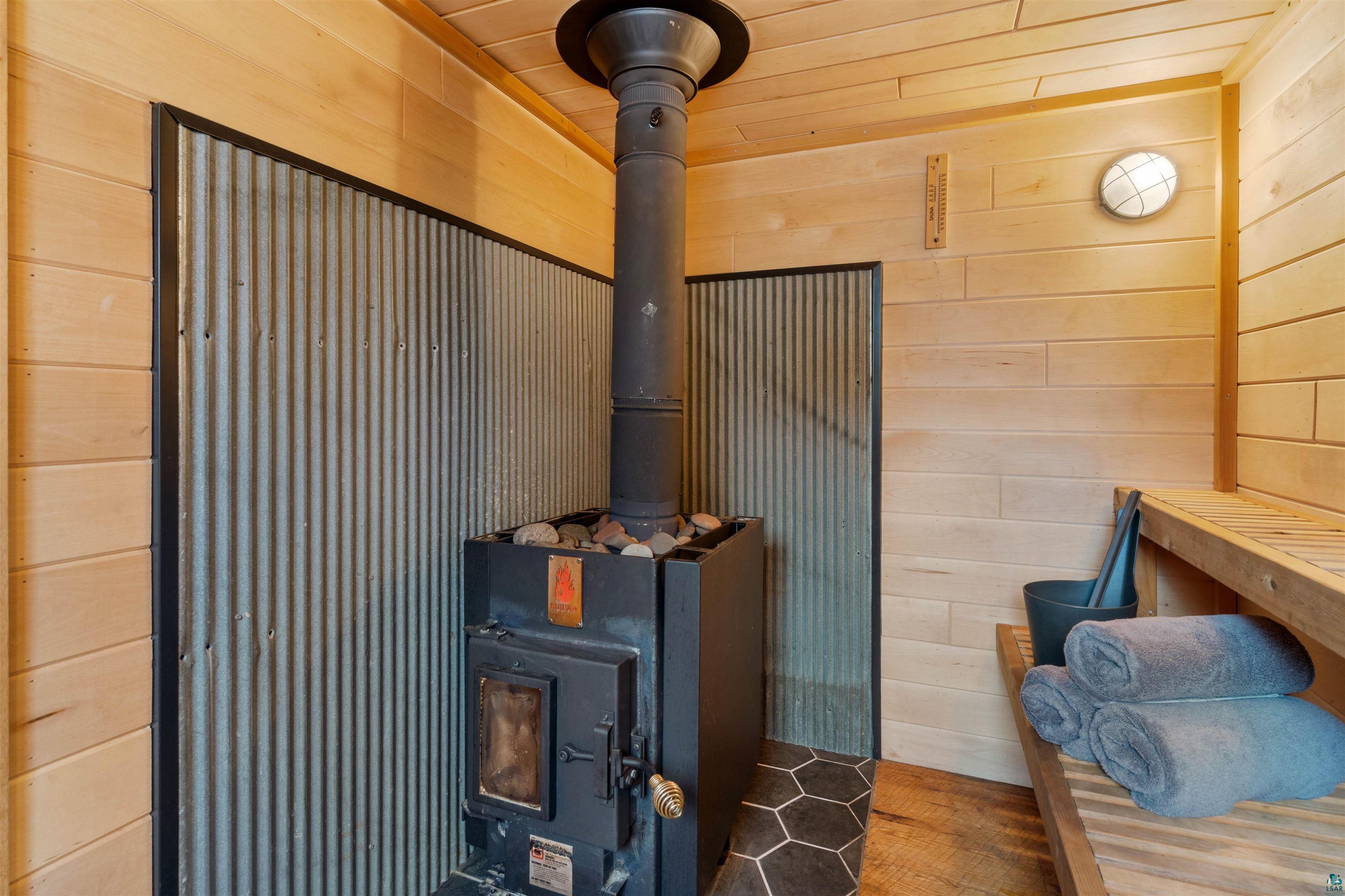 59 East Riverside Road Esko, MN 55733 - Photo 40 of 48 Detailed view of a sauna, wood walls, and a wood stove