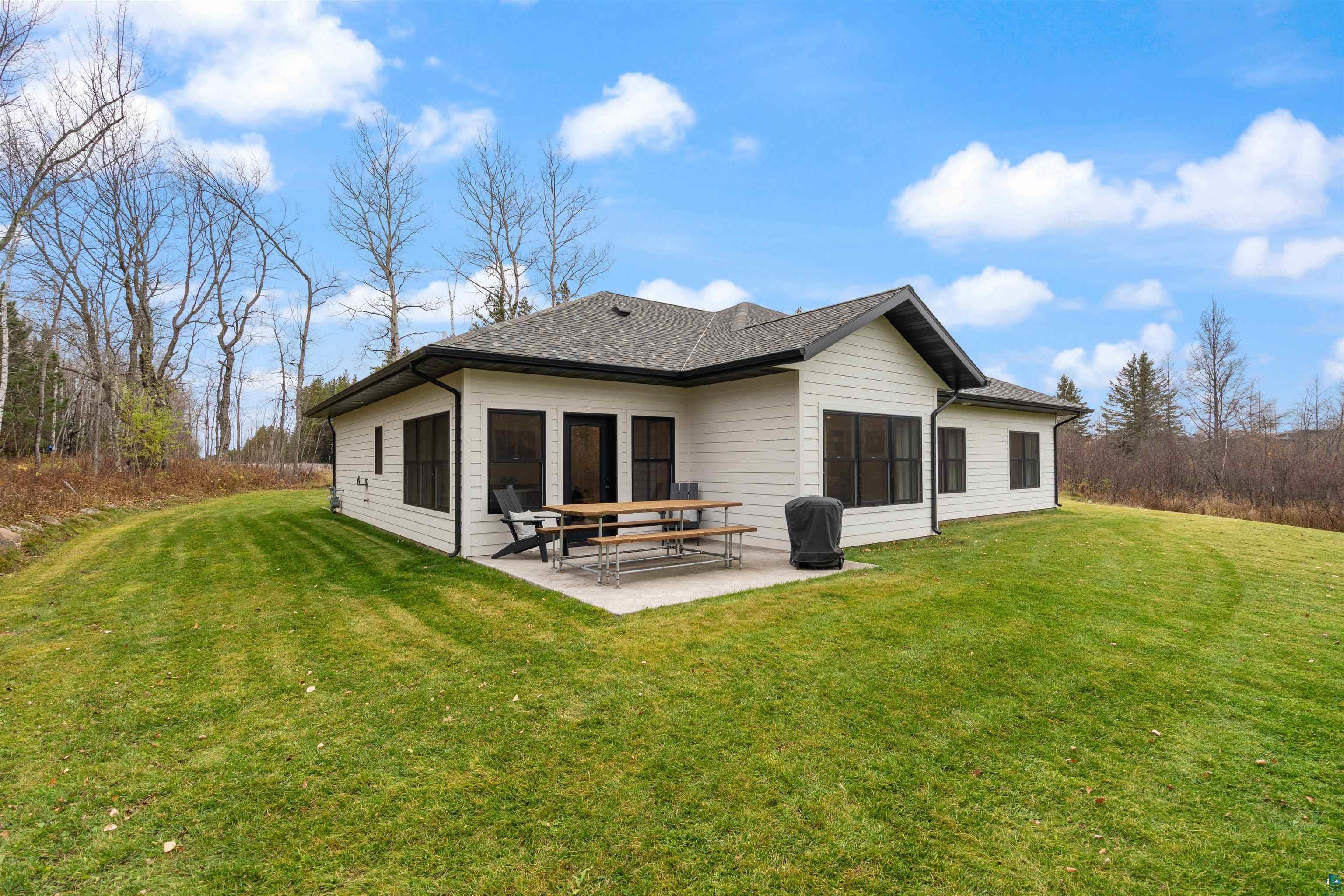 59 East Riverside Road Esko, MN 55733 - Photo 4 of 48 Rear view of property featuring a lawn, a patio, and roof with shingles