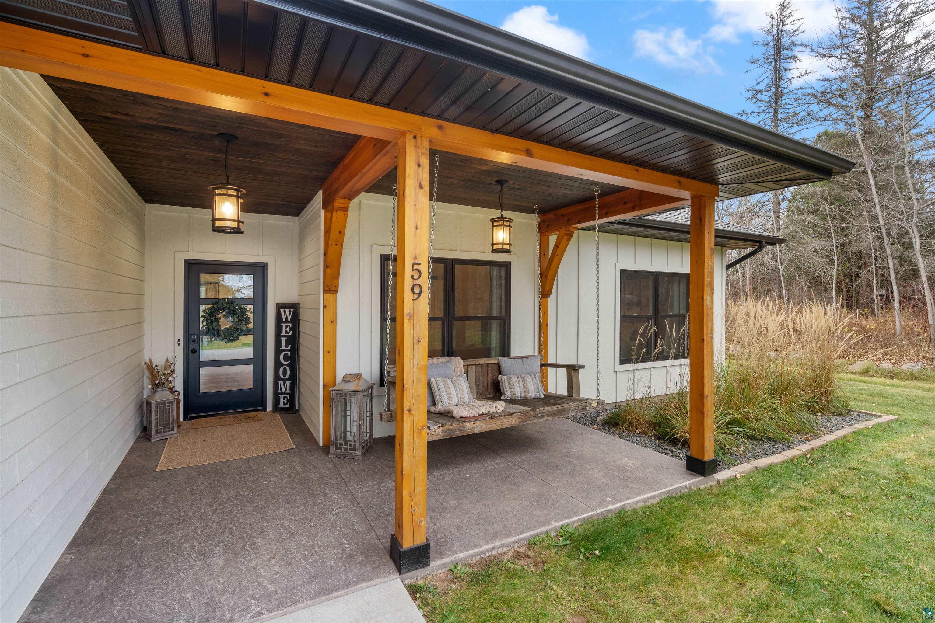 59 East Riverside Road Esko, MN 55733 - Photo 46 of 48 Property entrance featuring covered porch, board and batten siding, and a yard