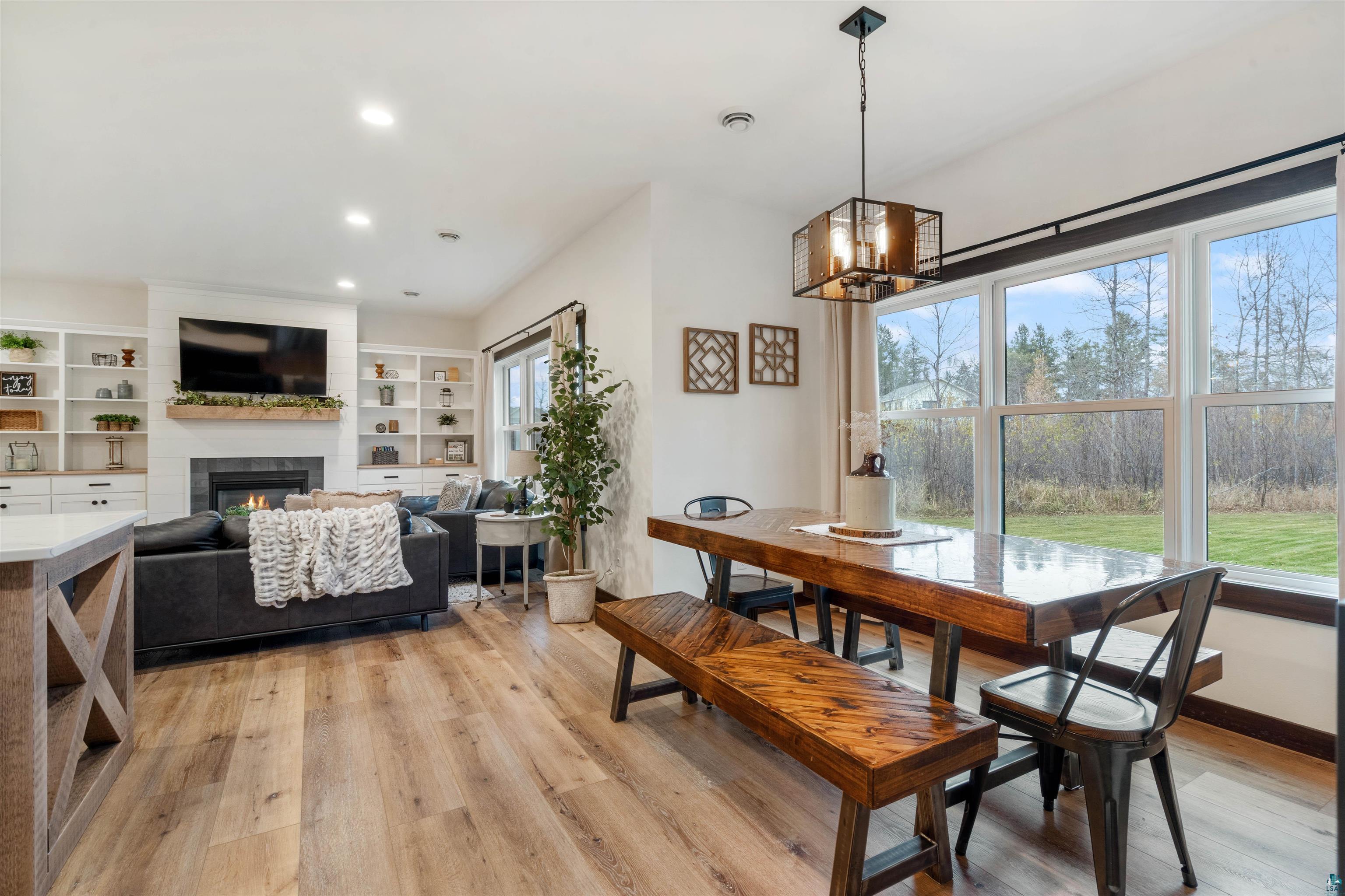 59 East Riverside Road Esko, MN 55733 - Photo 8 of 48 Dining space with light wood-style floors, a fireplace, and suspended lighting