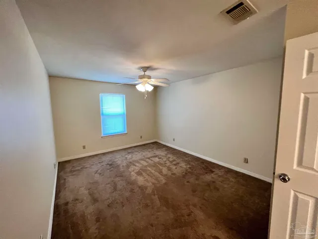 an empty room with a view of a kitchen