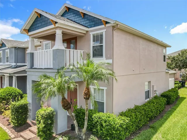 front view of a house with potted plants and more windows