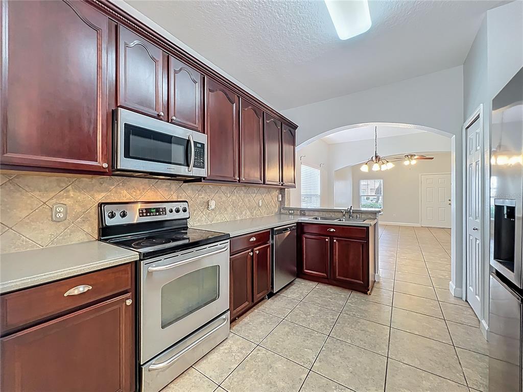 16178 Old Ash Loop Orlando, FL 32828 - Photo 15 of 58 a kitchen with stainless steel appliances granite countertop a stove microwave and refrigerator