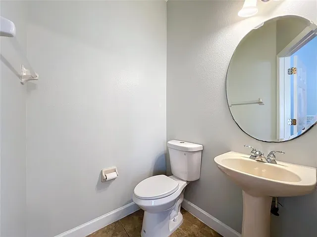 an empty room with wooden floor and a ceiling fan