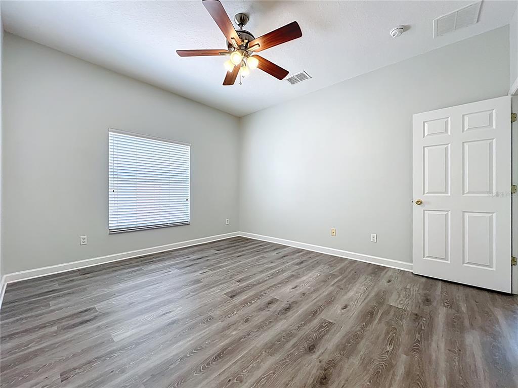 16178 Old Ash Loop Orlando, FL 32828 - Photo 21 of 58 an empty room with wooden floor chandelier fan and windows