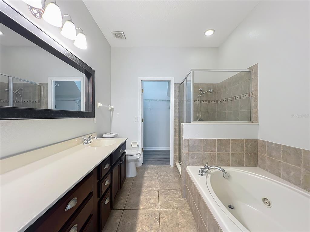 16178 Old Ash Loop Orlando, FL 32828 - Photo 23 of 58 a bathroom with a tub sink and mirror
