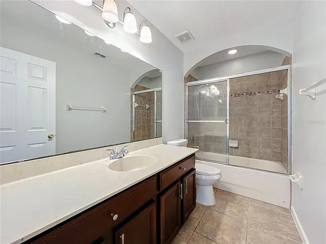 an empty room with wooden floor and a ceiling fan