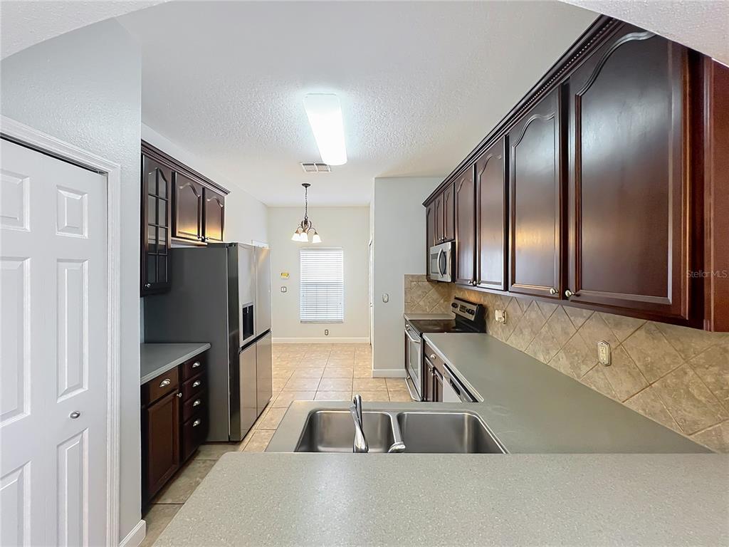 16178 Old Ash Loop Orlando, FL 32828 - Photo 10 of 58 a kitchen with a refrigerator and a sink