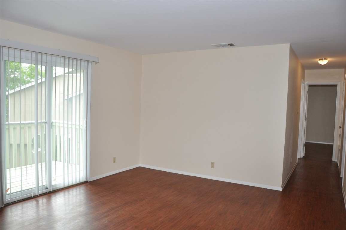 10810 Topperwein Drive, Unit C Austin, TX 78758 - Photo 4 of 11 Unfurnished room with dark wood-style flooring and baseboards