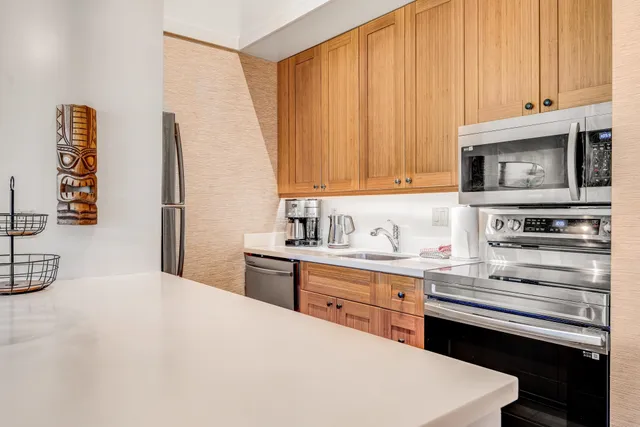 a kitchen with stainless steel appliances a stove a microwave and a sink