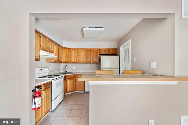 a kitchen with stainless steel appliances granite countertop a stove a sink dishwasher and cabinets with wooden floor