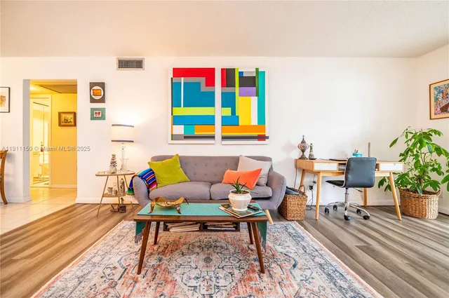 a living room with furniture wooden floor and a table