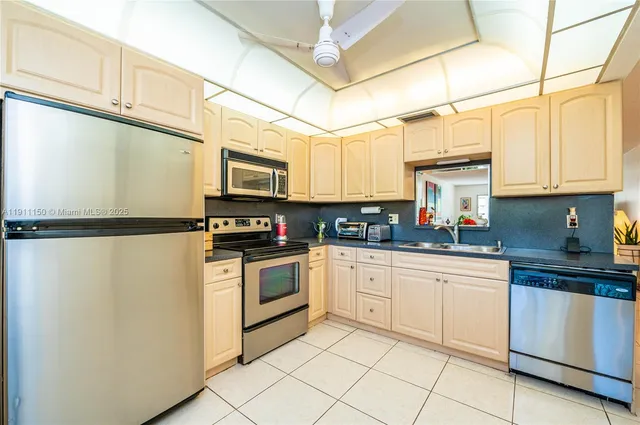 a kitchen with granite countertop cabinets stainless steel appliances and a sink