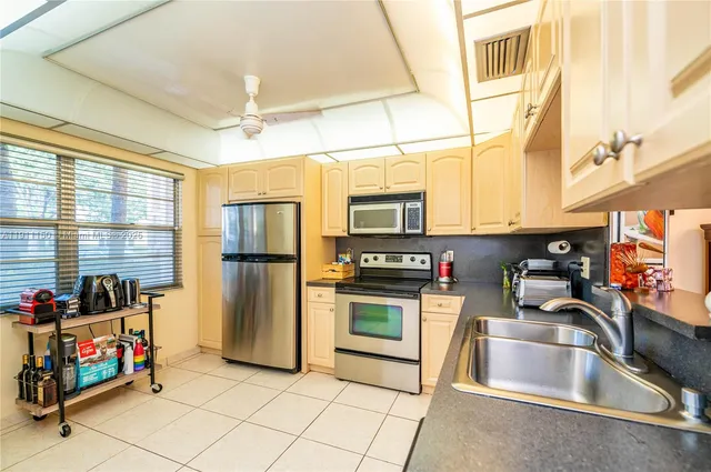 a kitchen that has a sink cabinets and stainless steel appliances