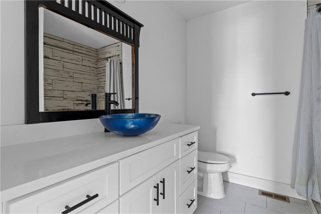 610 Madola Road, Unit 4 Epworth, GA 30541 - Photo 11 of 16 a bathroom with a toilet a sink and mirror