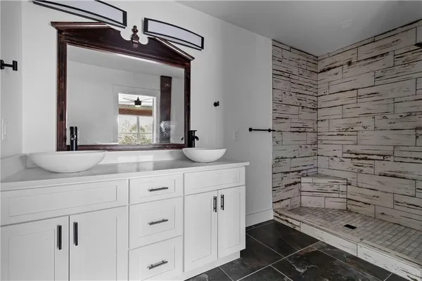 a bathroom with a granite countertop sink a toilet and a mirror