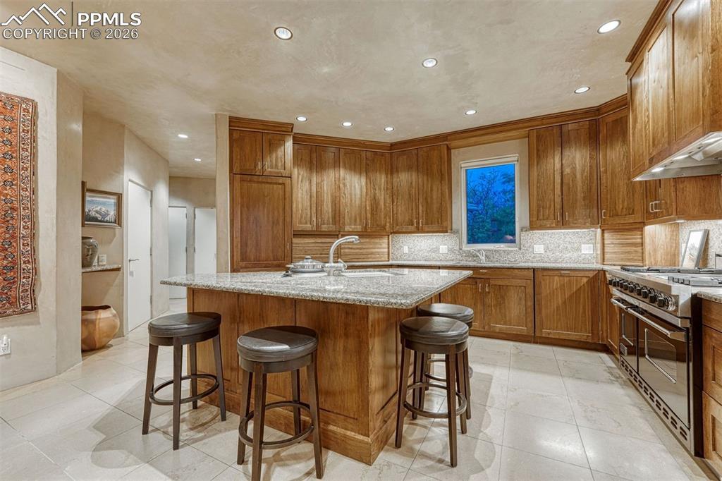 99 Bradburn Road Cotopaxi, CO 81223 - Photo 11 of 50 a kitchen with granite countertop wooden cabinets and stainless steel appliances