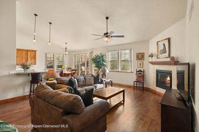 a living room with furniture a fireplace and a chandelier